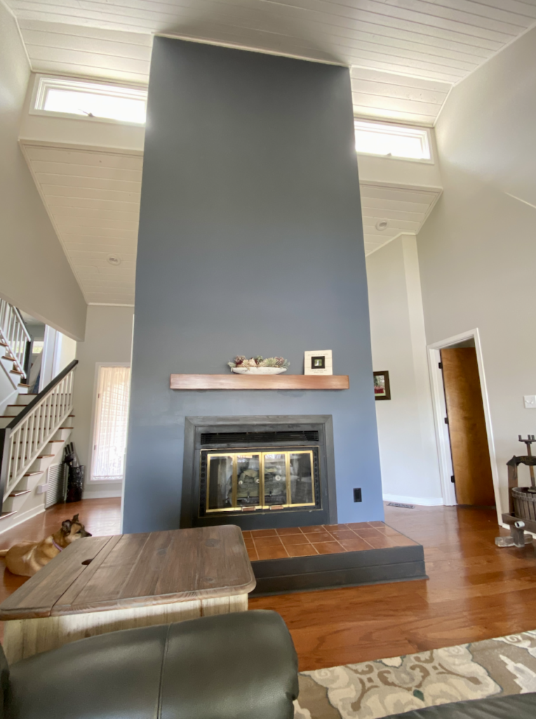 A fireplace accent wall is painted with SW Granite Peak paint and paired with SW Grey Heron walls.