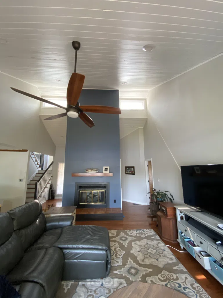 A living room is painted with SW Grey Heron walls, SW Pure White ceiling and a Granite Peak accent wall.