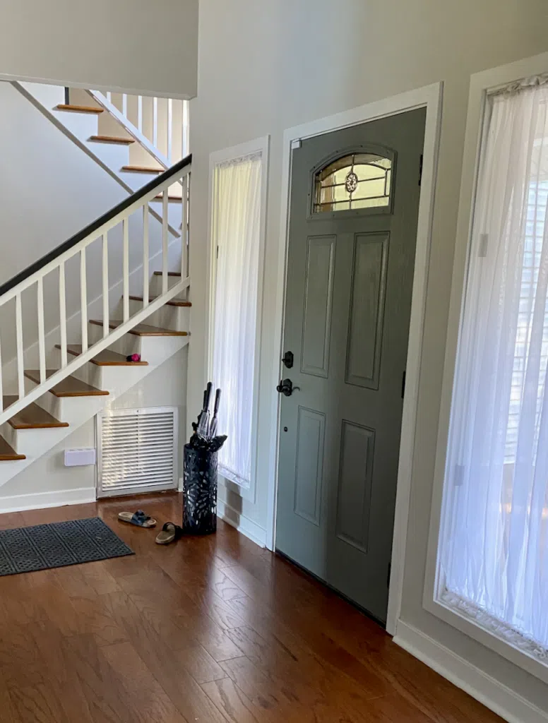 An entry way features SW Grey Heron walls with an SW Attitude Gray front door. 