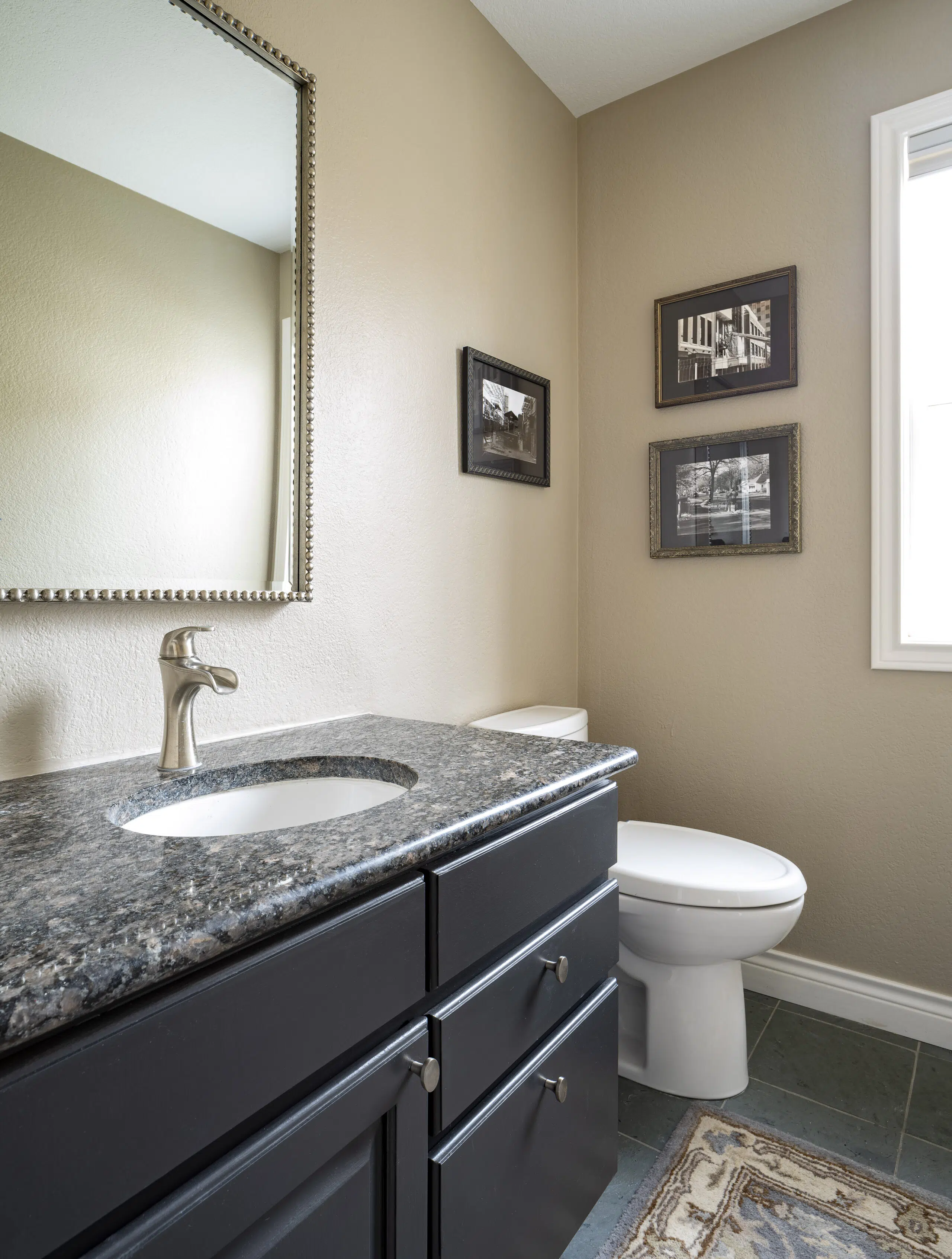 A bathroom vanity is painted with BM Onyx and walls painted with BM Stone Hearth, one of the best taupe paint colors