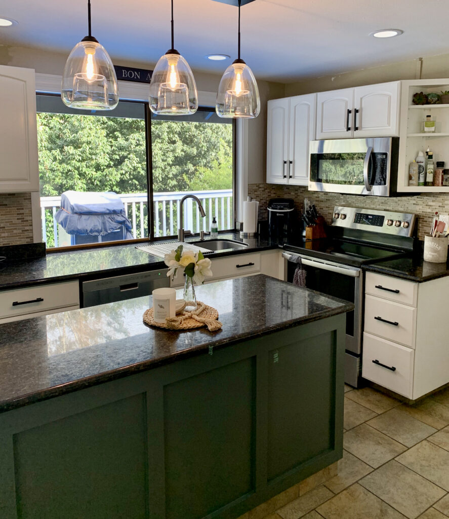 A kitchen painted with SW Alabaster kitchen cabinets and an SW Pewter Green kitchen island.