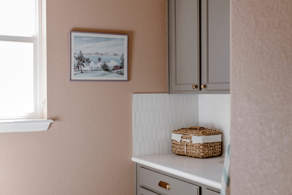 A laundry room is painted with SW Pinky Beige paint and Chelsea Gray cabinets 