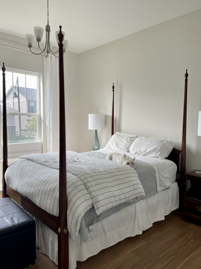 A bedroom is painted with Sherwin-Williams Mortar paint in this Simply White color palette. 
