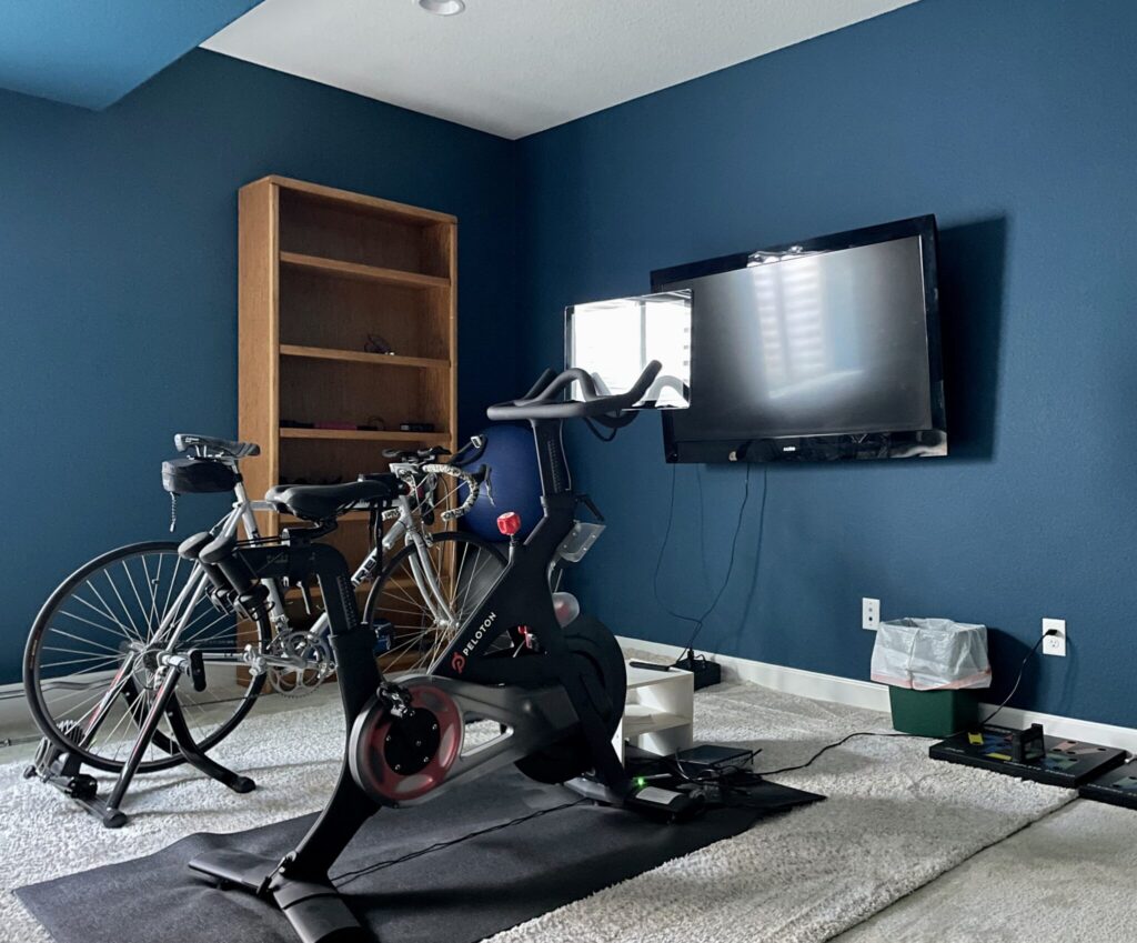 A basement workout room is painted with Benjamin Moore Slate Teal walls.