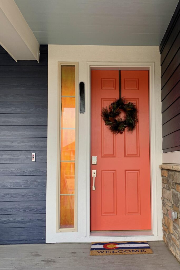 A home's front door is painted with SW Quite Coral