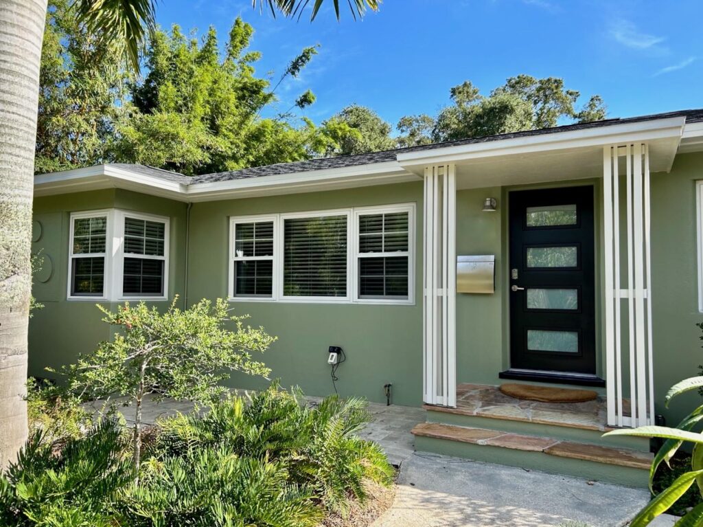 Florida house with SW Green Onyx exterior stucco, SW Oyster White trim and SW Black Magic front door.