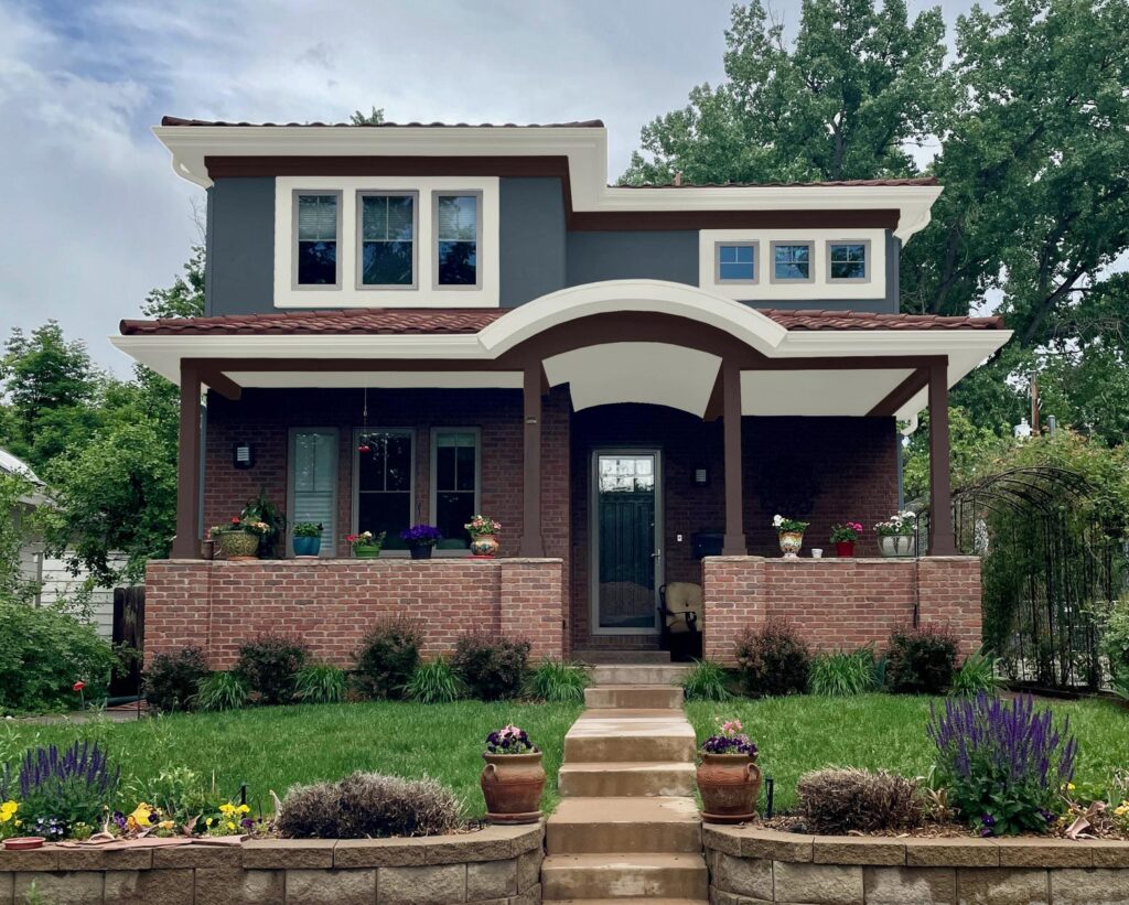 A red brick home is shown painted with Sherwin-Williams Sea Serpent exterior paint. 