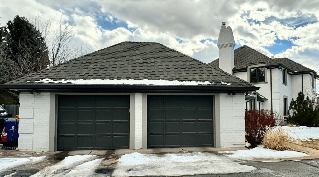 A garage door is painted with SW Black Fox, one of the best black paint colors for front doors.