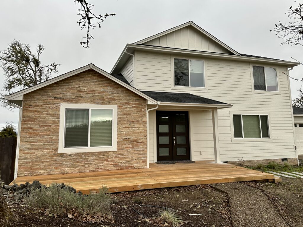 A home features SW White Duck exterior paint with red brick accents.