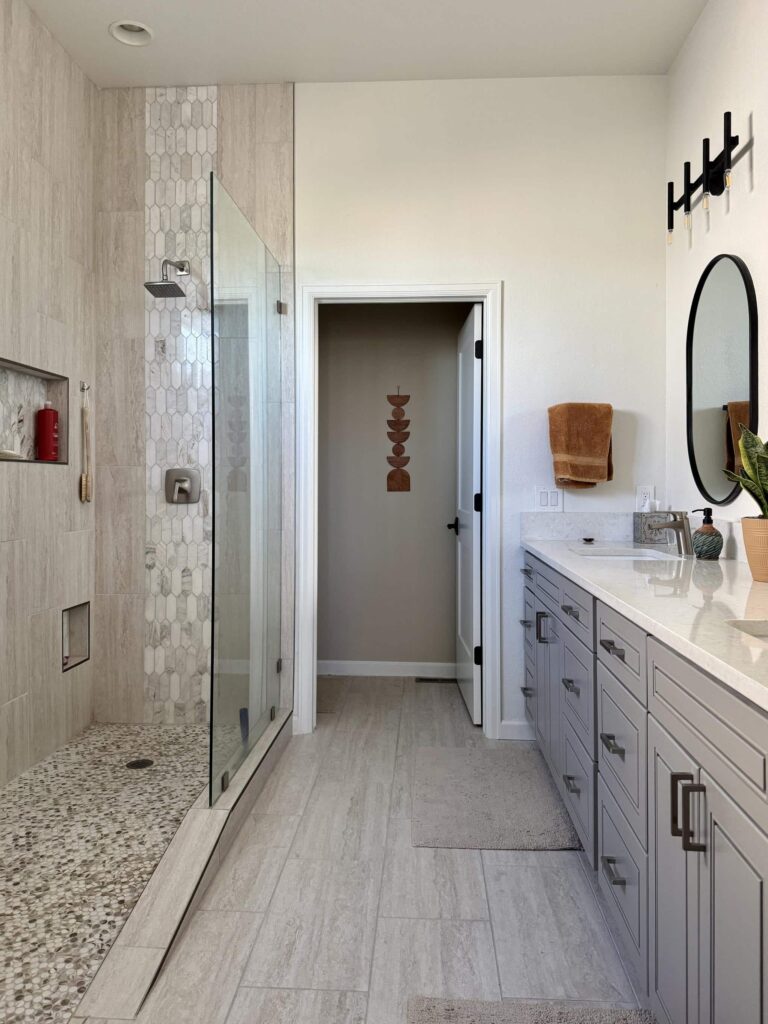 A bathroom features SW Alabaster bathroom walls with warm beige tile and warm wood floors.