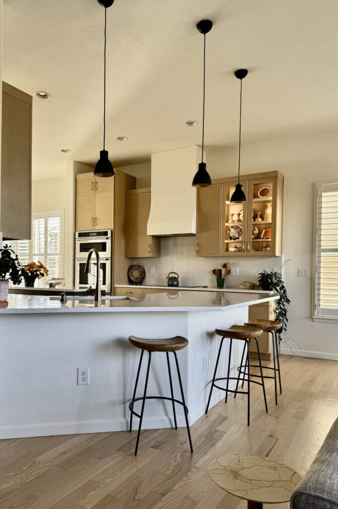 A kitchen features SW Alabaster kitchen walls with light wood cabinets