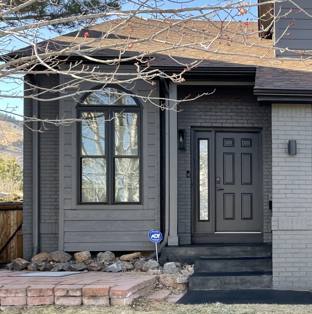 A home features BM Iron Mountain siding and a SW Black Magic front door.