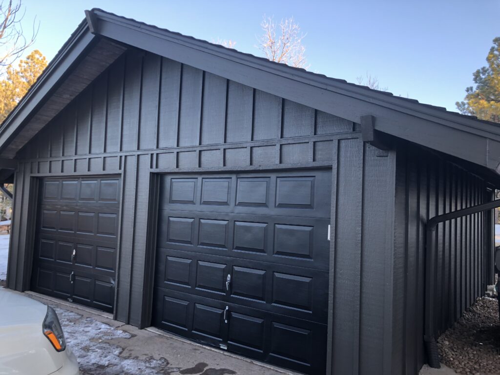 A garage features SW Urbane Bronze siding and Tricorn Black garage doors.