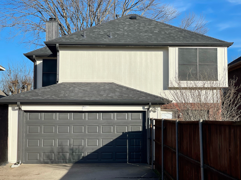 A home features SW Urbane Bronze garage doors and trim with SW Natural Choice siding. 
