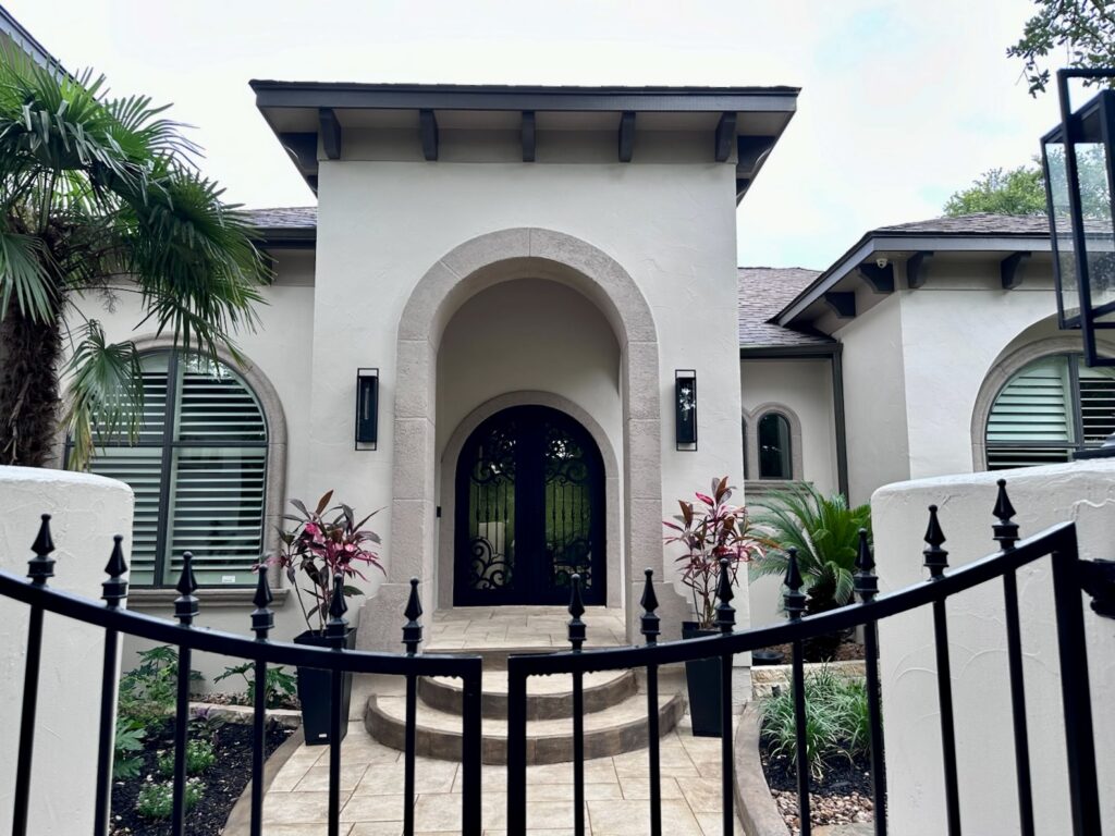 A home features SW Urbane Bronze front door with SW Accessible Beige stucco and SW Tony Taupe trim. Explore