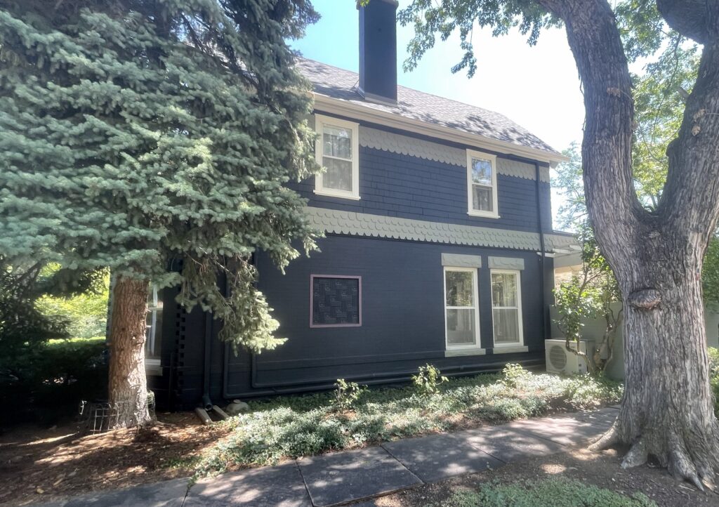 A home features BM Westcott Navy siding and BM Seashell exterior paint. 