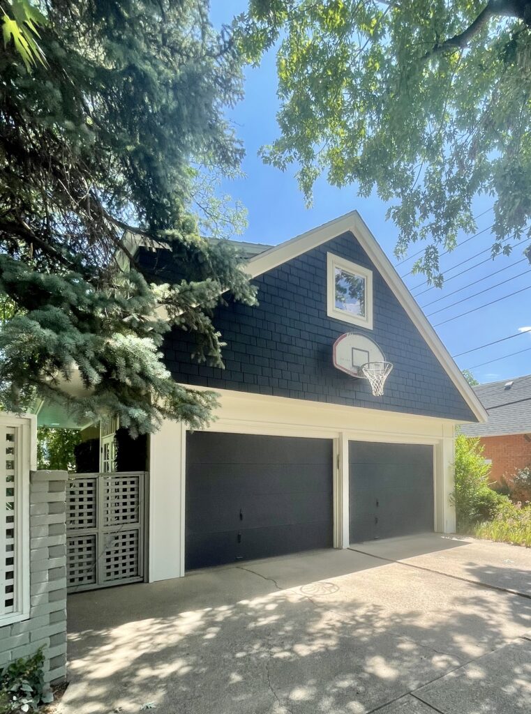 A garage features BM Westcott Navy siding and BM Seashell exterior paint.