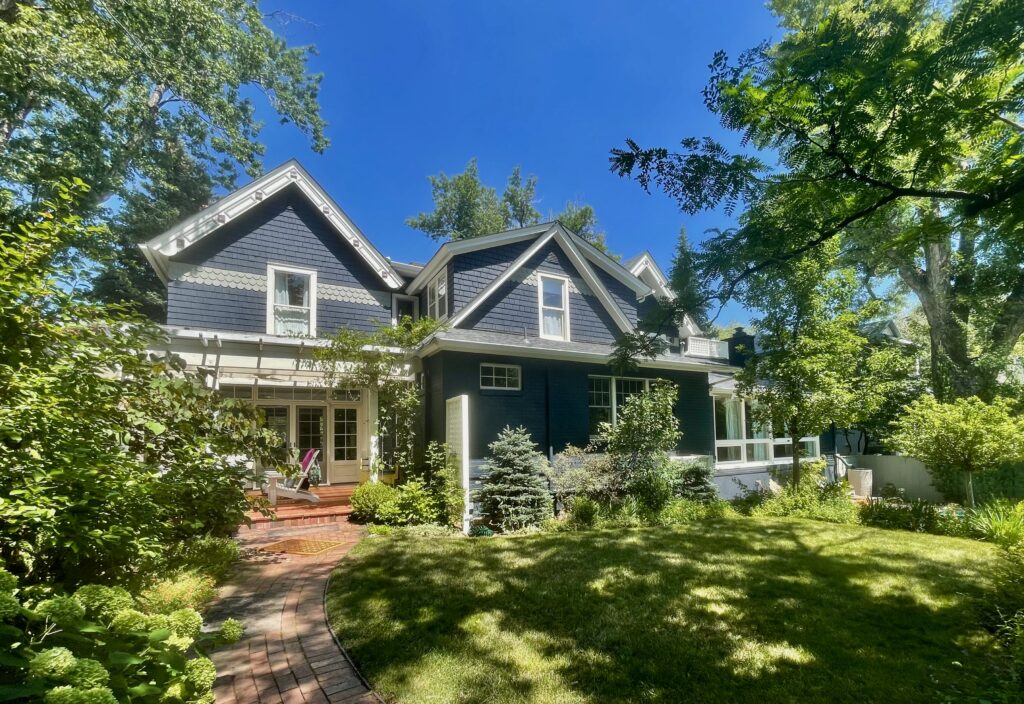 A historic home in Colorado features a Benjamin Moore Westcott Navy exterior color palette. 