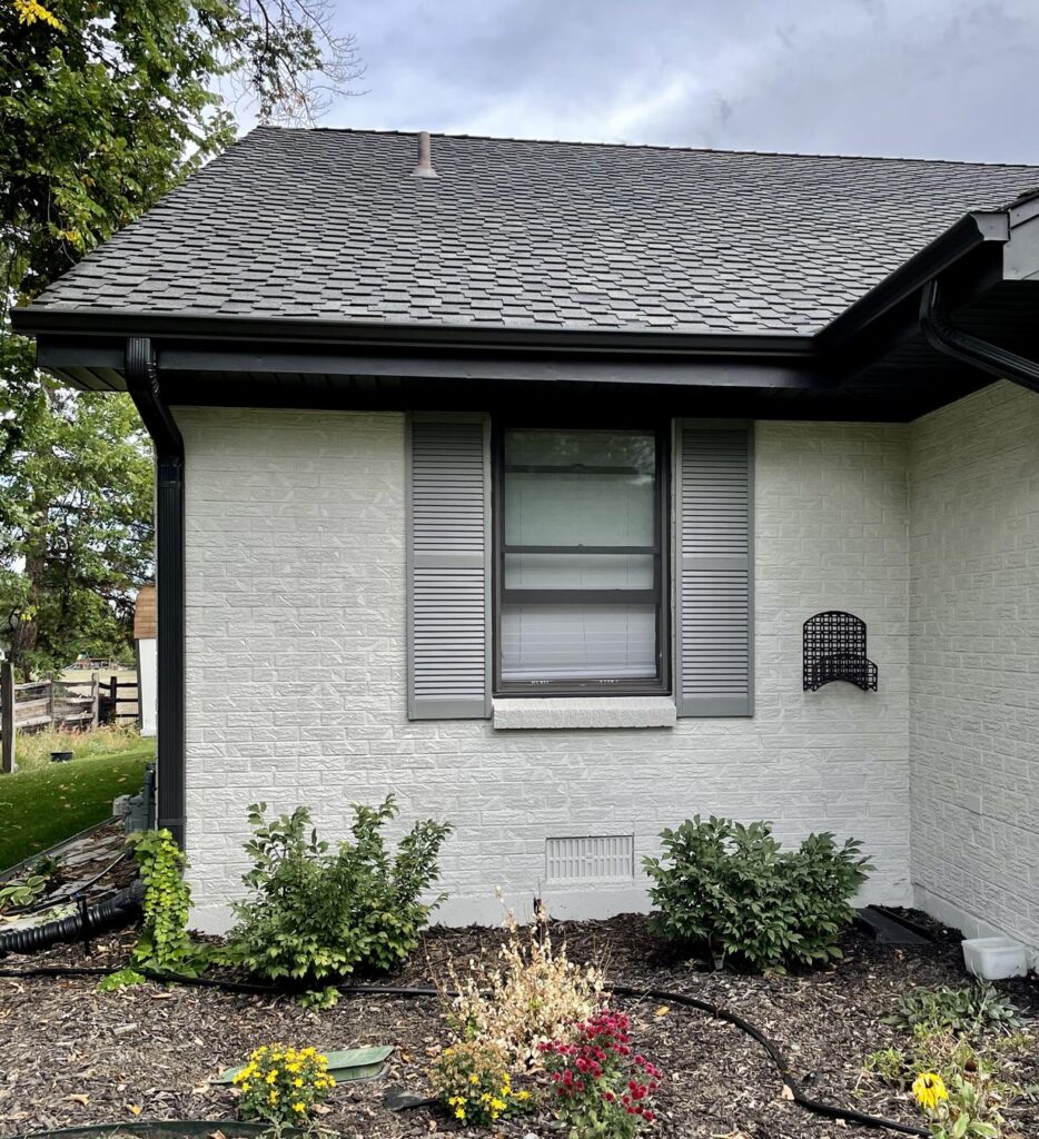 A home features SW Gossamer Veil painted brick exterior with Classic French Gray shutters for a low contrast color palette look.