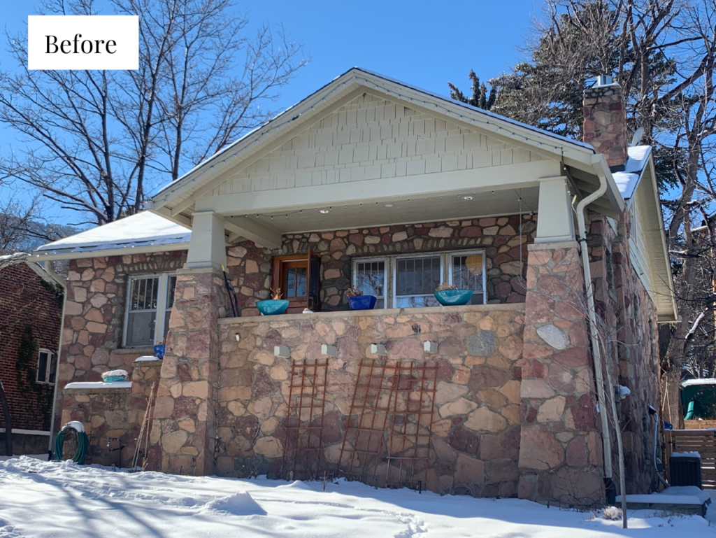 A home features light siding and warm stone