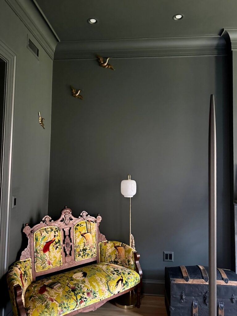 A color drenched bedroom is painted with Sherwin-Williams Rock Bottom dark green paint