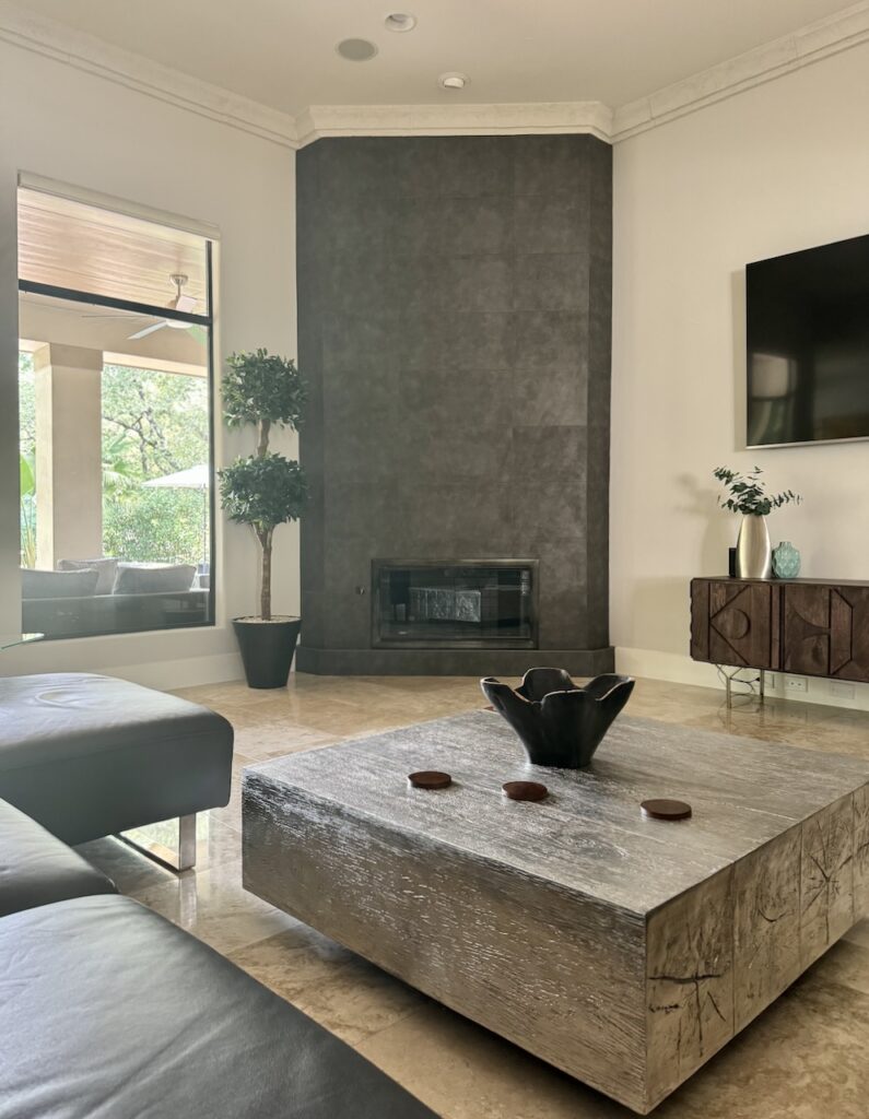 A Sherwin-Williams Egret White living room with large bronze fireplace.