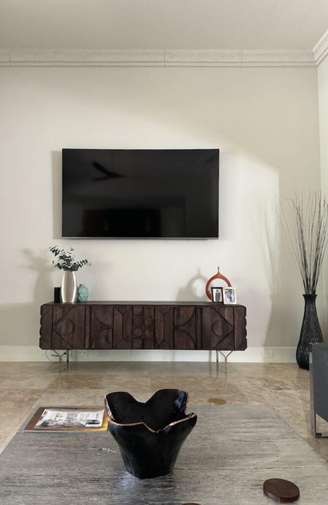 A Sherwin-Williams Egret White living room with large bronze fireplace. 