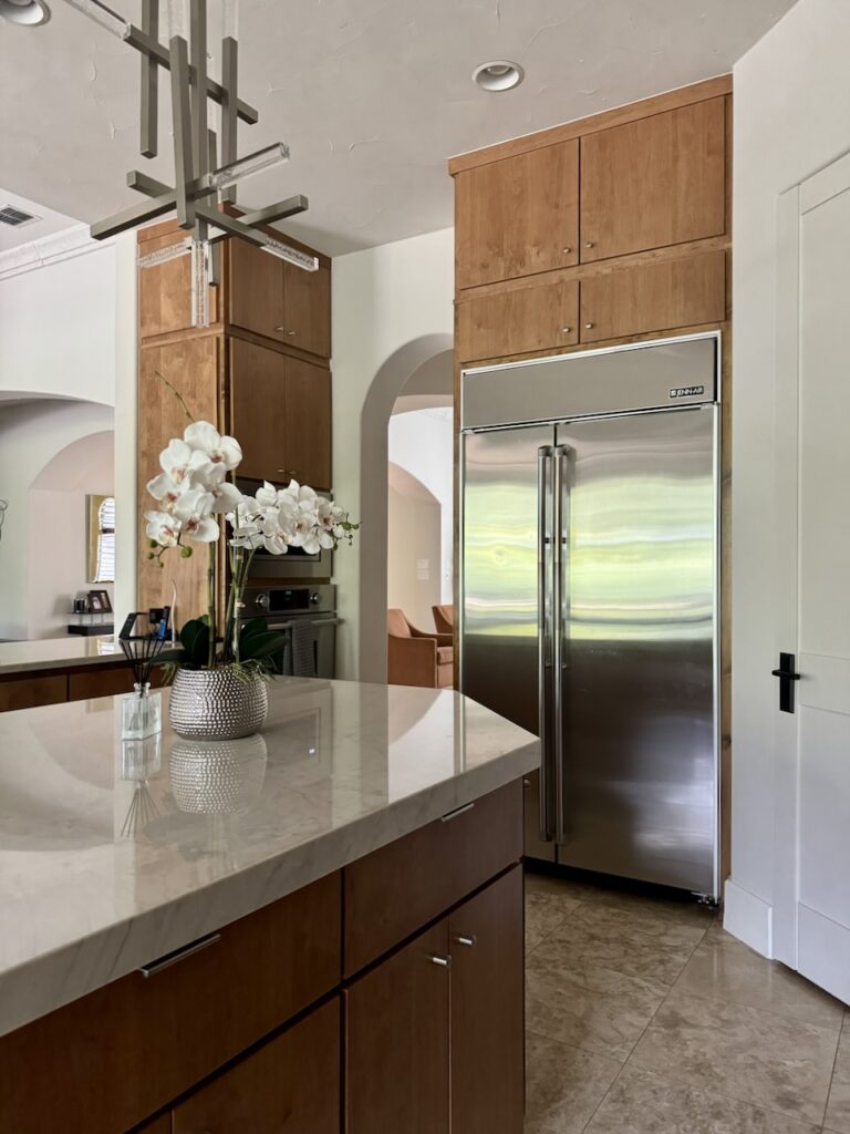 A kitchen features SW Egret White walls with wooden cabinets. 