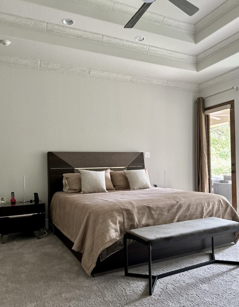 A master bedroom is painted with Sherwin-Williams Egret White paint, one of the best taupe paint colors