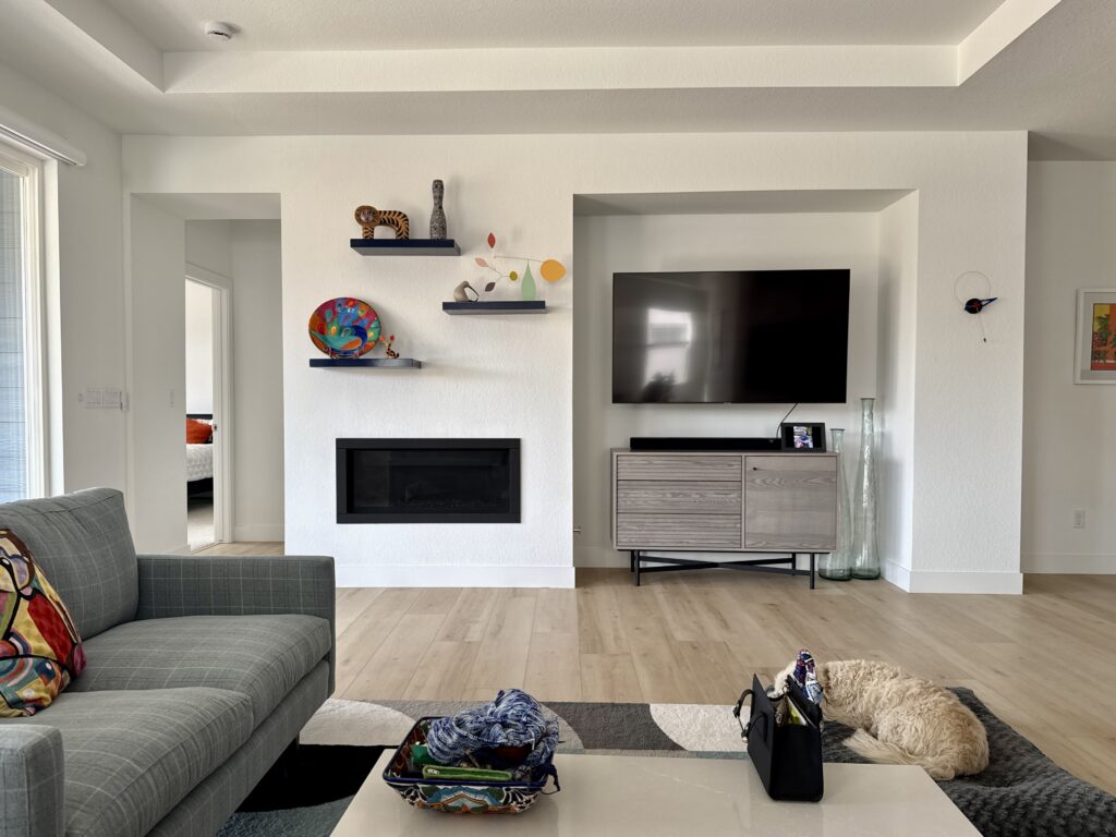 A living room painted with SW Extra White walls and decorated with colorful art. 