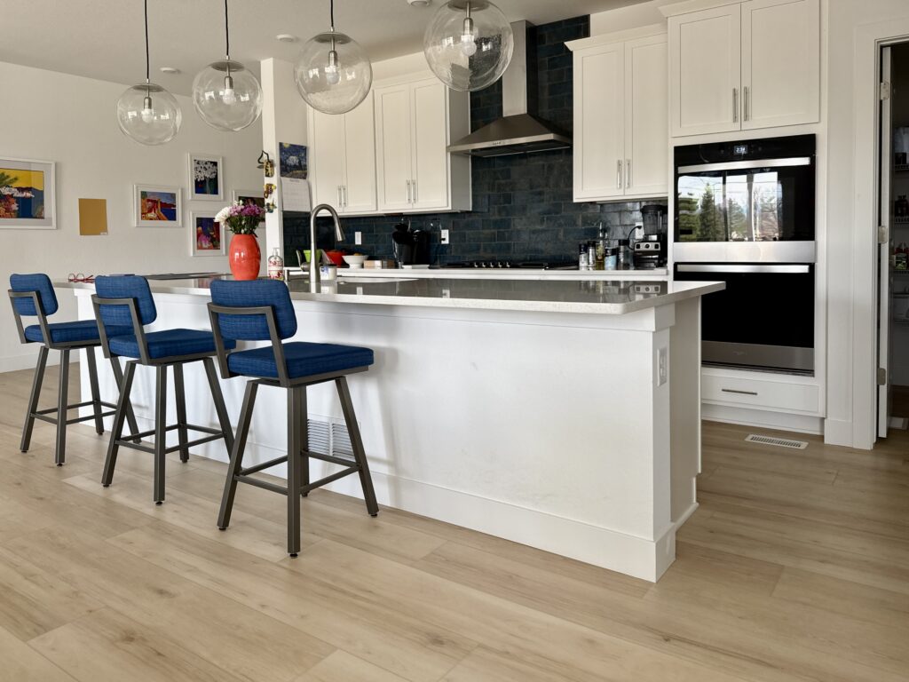 A kitchen features SW Extra White walls and a navy blue tile backsplash.