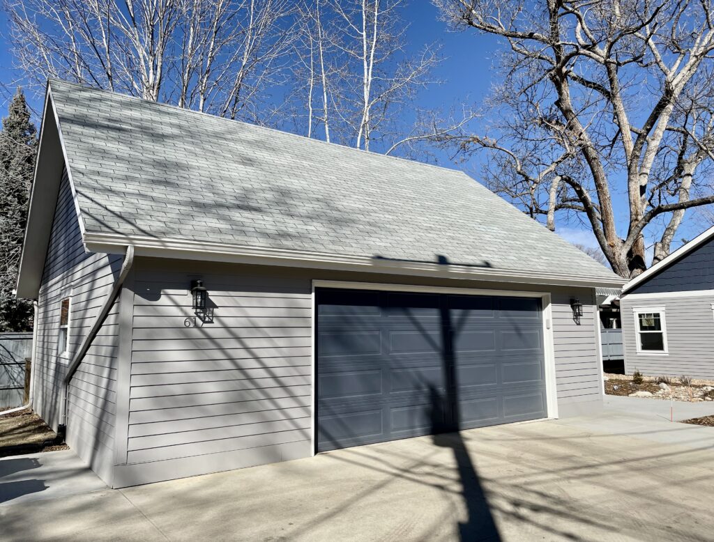 A home is painted with BM Willow Creek exterior paint, BM Hale Navy accents and BM Classic Gray exterior white trim.