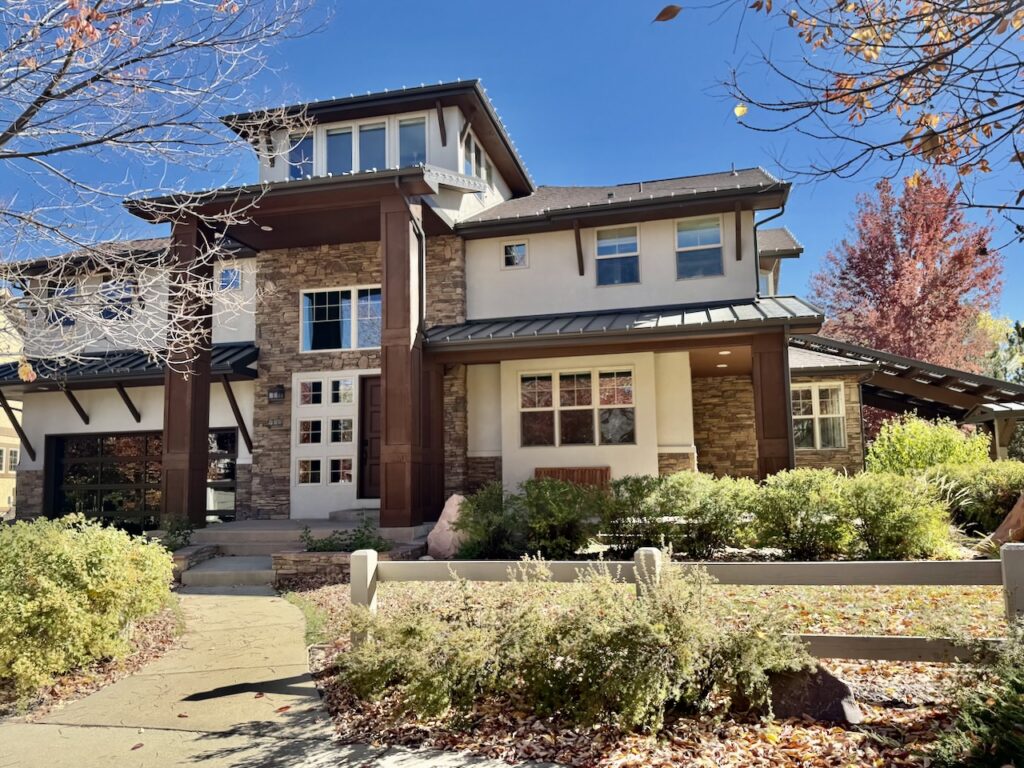 A home features SW Accessible Beige stucco exterior and SW Black Fox painted metal roofs.