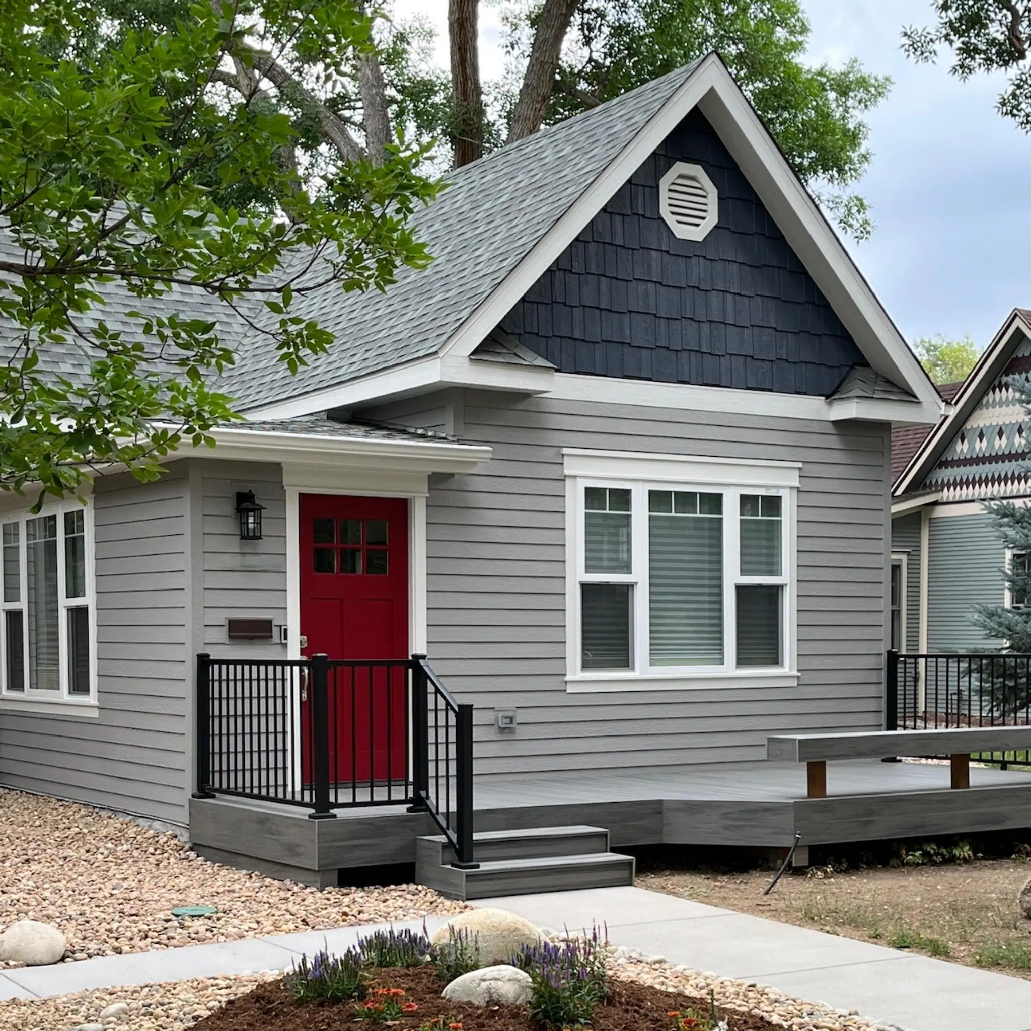 A home is painted with BM Willow Creek exterior paint with BM Hale Navy accents and BM Classic Gray trim.