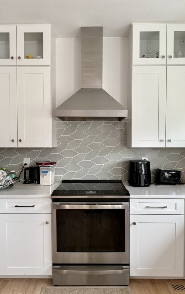 A kitchen is painted with Sherwin-Williams Snowbound paint and white cabinets.