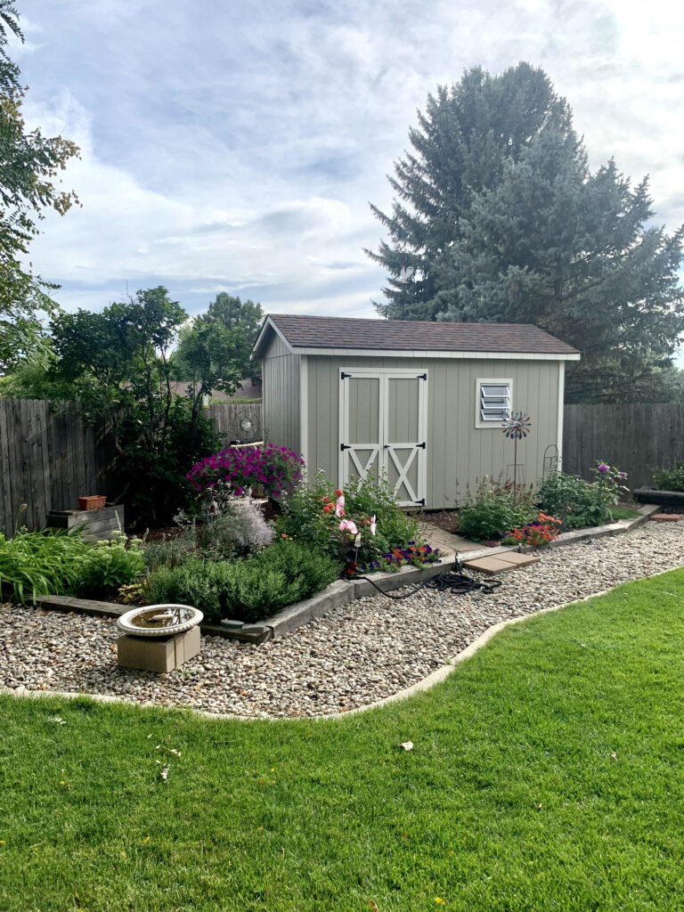 A shed painted with beige exterior paint and SW Shoji White exterior trim.