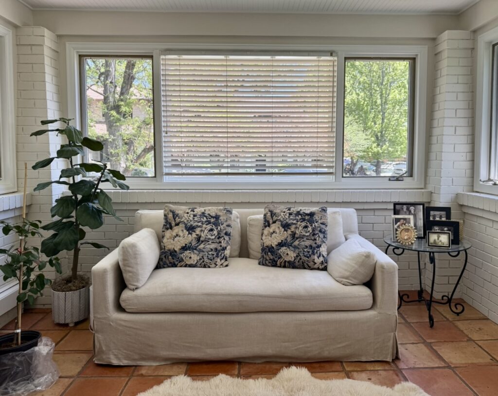 A living room painted with SW Shoji White paint and terracotta tile floors.