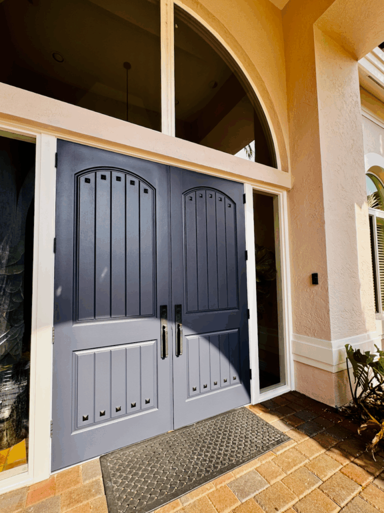 A home features pink exterior house paint and a BM Hale Navy front door paint color.