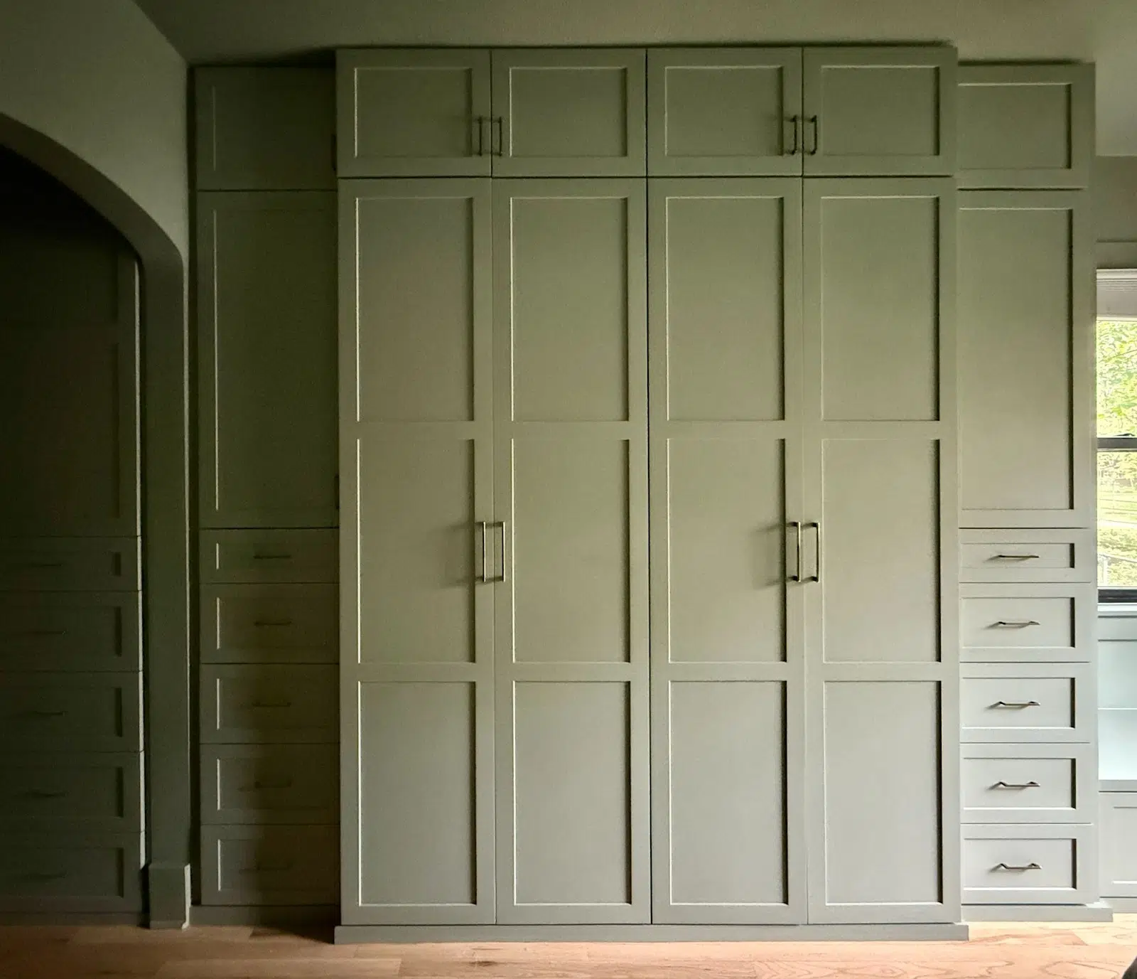 A built-in cabinet painted with SW Evergreen Fog, one of the best green paint colors on the market.