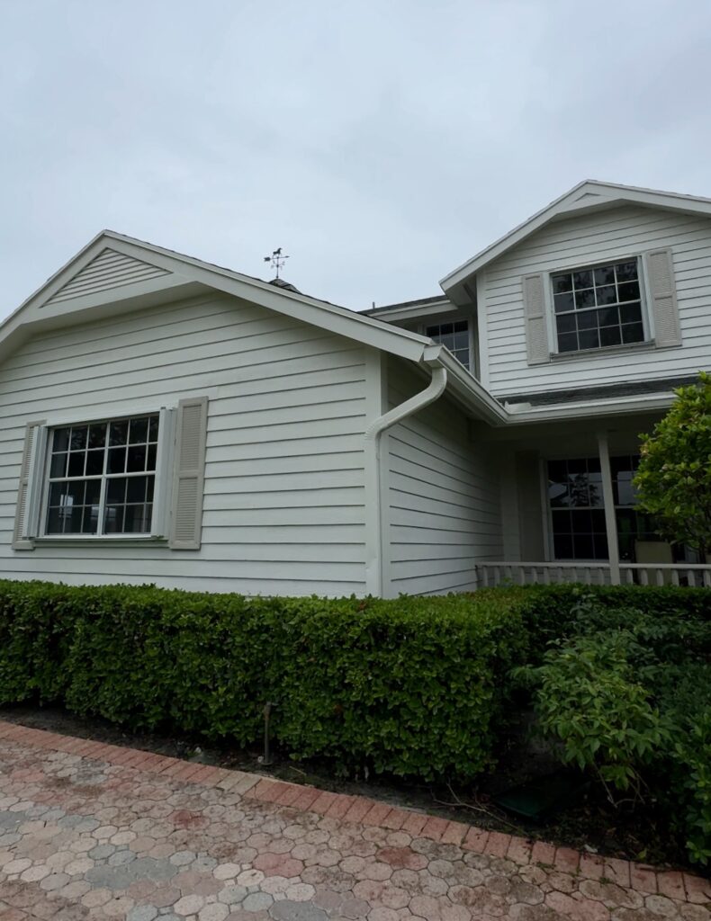 A Florida home features a BM Swiss Coffee exterior paint color palette.