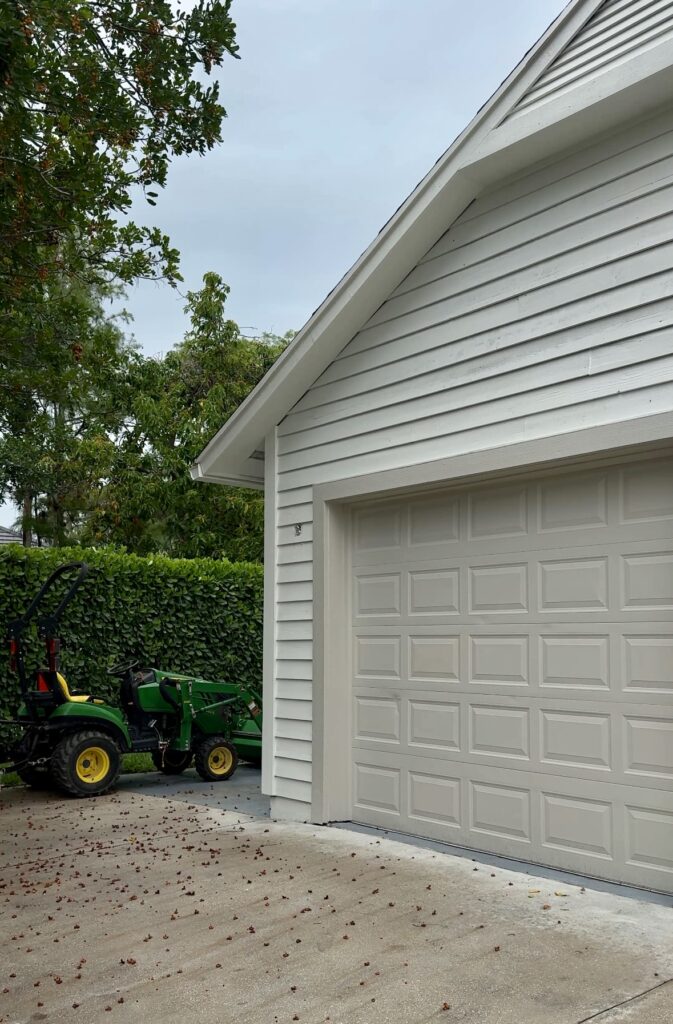 A home features BM Revere Pewter garage doors in a low contrast exterior color palette. 