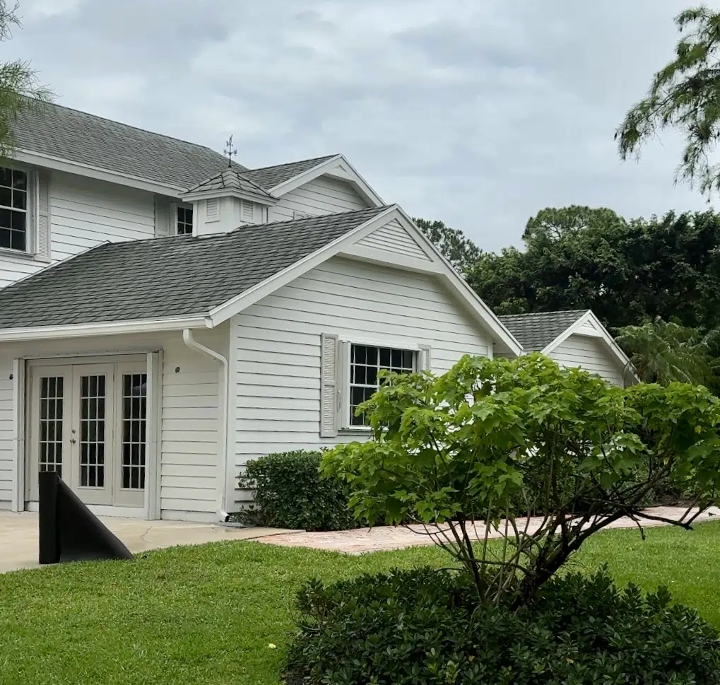 A home features BM Swiss Coffee exterior paint with BM Revere Pewter exterior trim. 