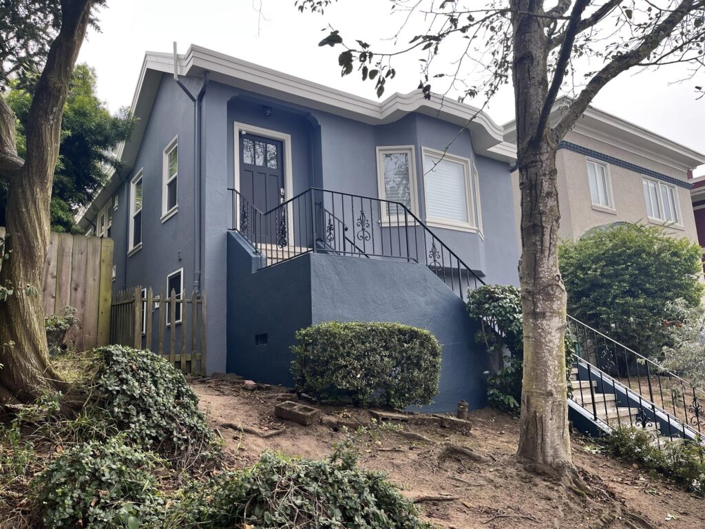 A home features a Sherwin-Williams Sea Serpent exterior with Sherwin-Williams Origami White exterior trim.