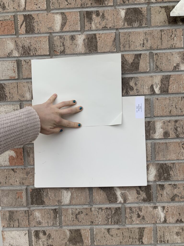 SW Neutral Ground paint swatch next to brick