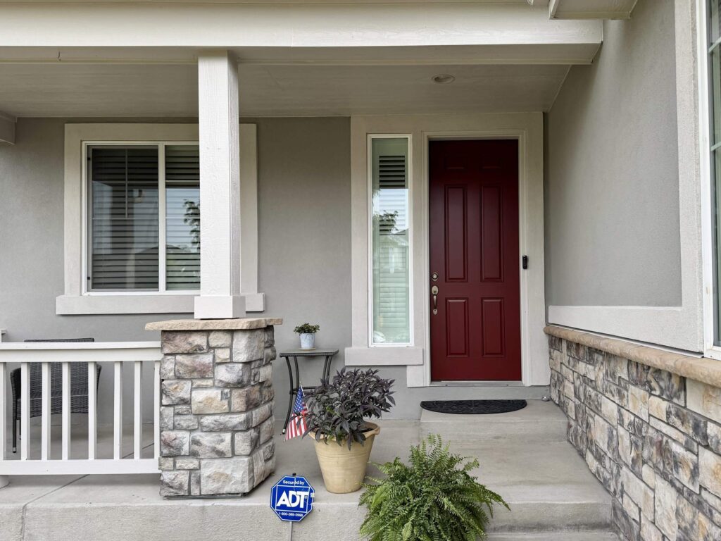 A home features SW Dorian Gray siding and SW Sun Dried Tomato front door.