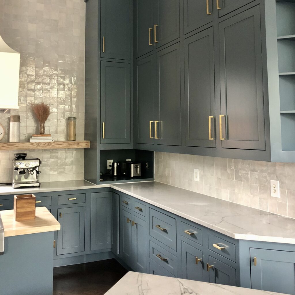 A home features BM Blue Spruce kitchen cabinets with gold fictures.