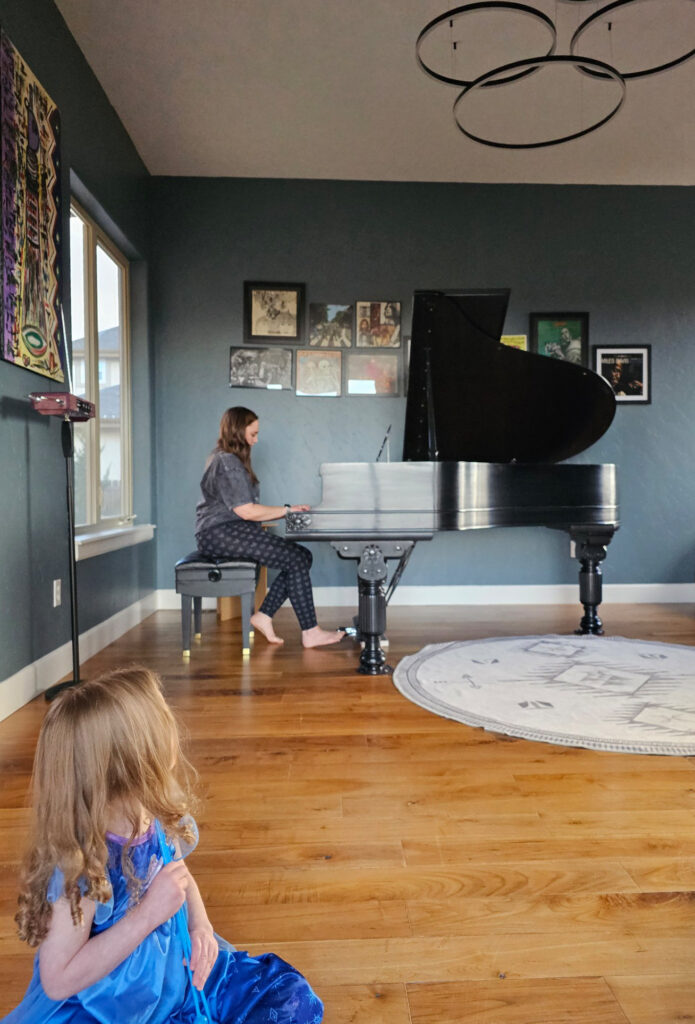 A music room is painted with Benjamin Moore Blue Spruce walls, which look great with the natural wood floors.