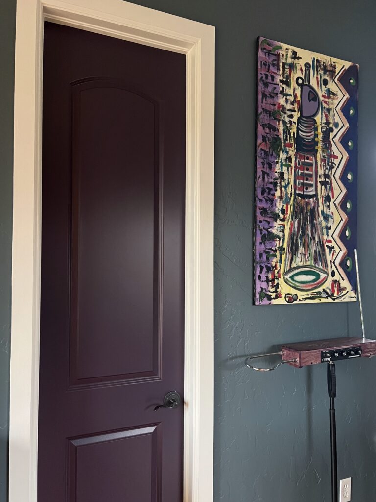 A room features BM Blue Spruce walls with BM Grappa interior front door. 