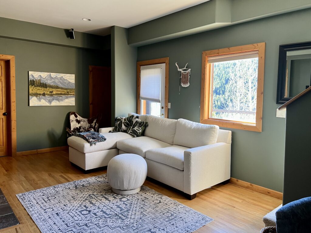 A BM Cambridge Green living room with white coach and gray mountain art.
