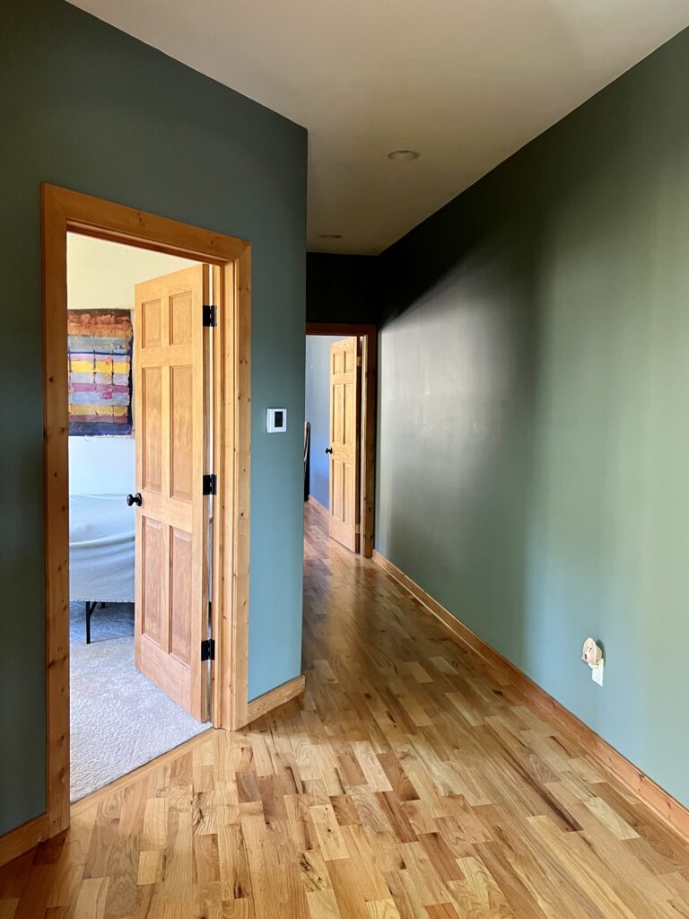 A hallway painted with BM Cambridge Green walls and BM White Dove ceiling.
